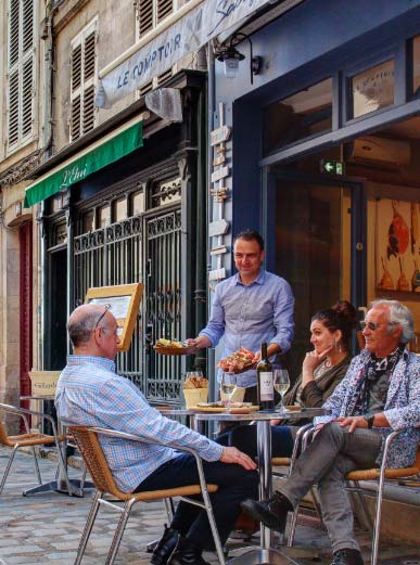 personnes attablées en terrasse au comptoir saoufé